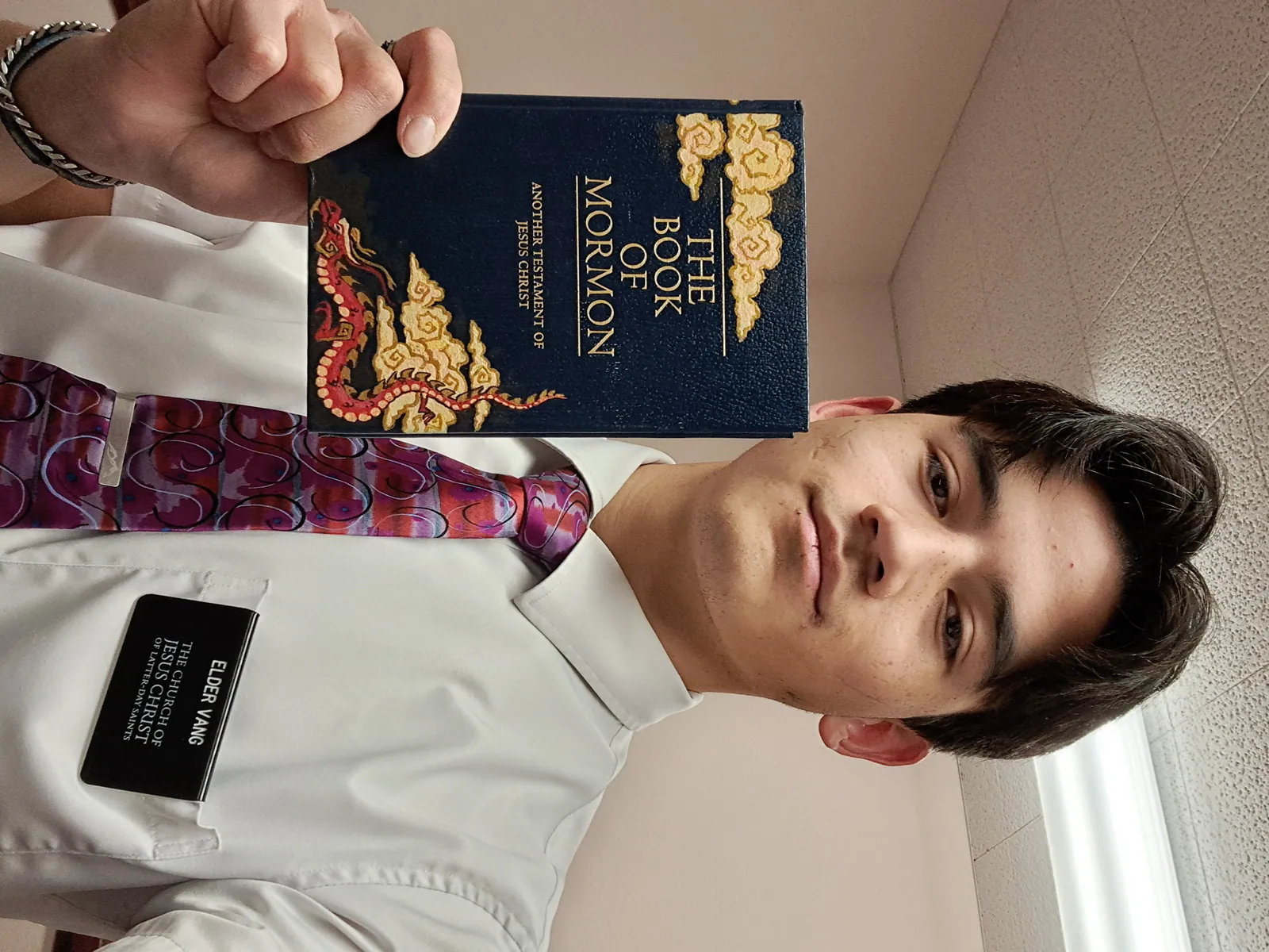 Elder Vang holding his painted Book of Mormon